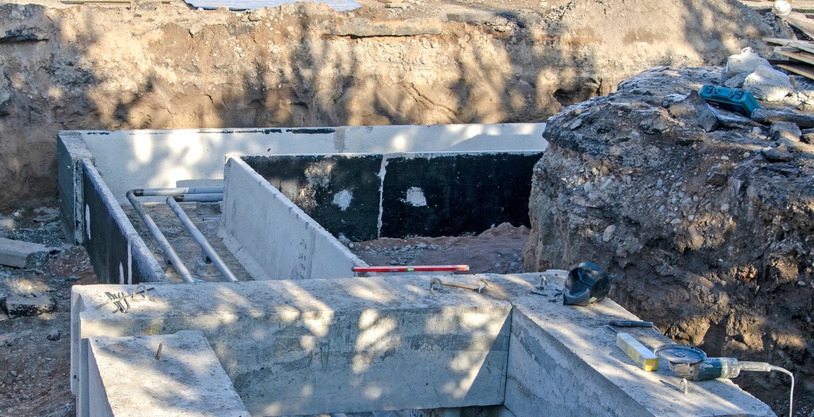 Underground gas pipework installation UK Excavated trench with concrete ducting and underground gas service pipework being installed on a UK site